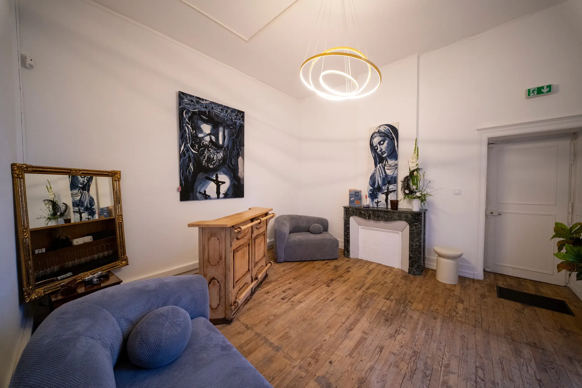 Le salon Lanterne : bar en bois, cheminée en marbre vert et lustre doré