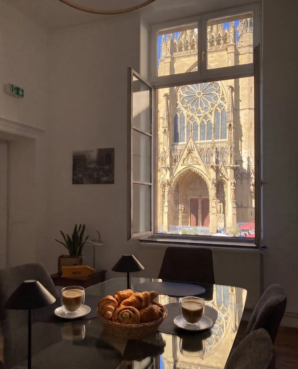 Petit déjeuner dressé devant la fenêtre ouverte sur la cathédrale
